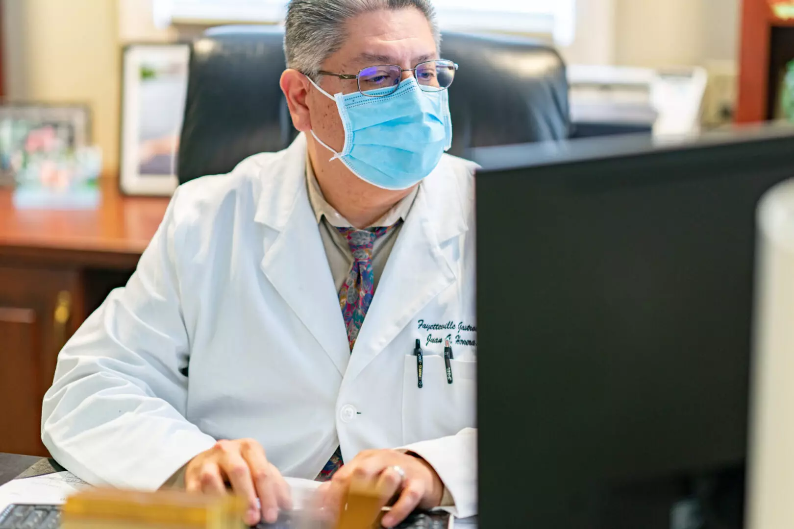 Doctor typing in front of a computer